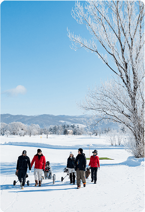 冬の雪景色の中でゴルフクラブなどを持ち歩く人々